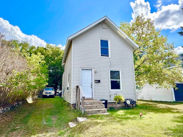 rear view of house featuring a lawn