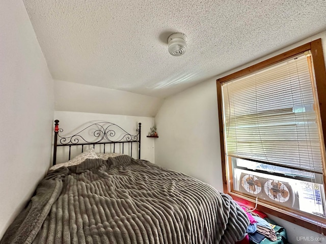 bedroom with a textured ceiling and lofted ceiling