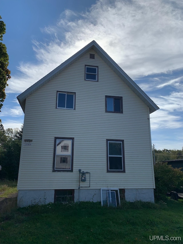 rear view of house featuring a yard