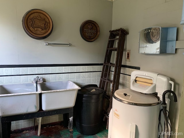 bathroom featuring tile walls and sink