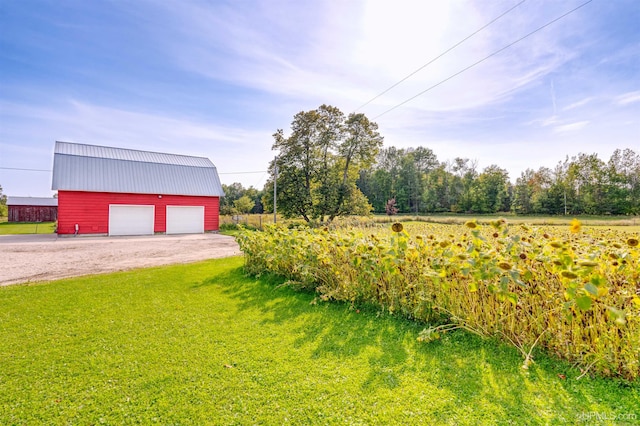 exterior space featuring an outdoor structure, a garage, and a rural view