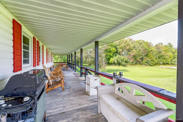 wooden terrace with a grill, a porch, and a yard