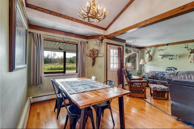 dining room with a notable chandelier, light hardwood / wood-style flooring, baseboard heating, and vaulted ceiling