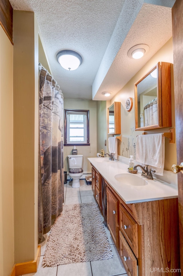 bathroom featuring vanity, toilet, a textured ceiling, and tile patterned floors