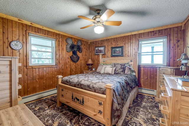 bedroom featuring a baseboard radiator, wood walls, and multiple windows