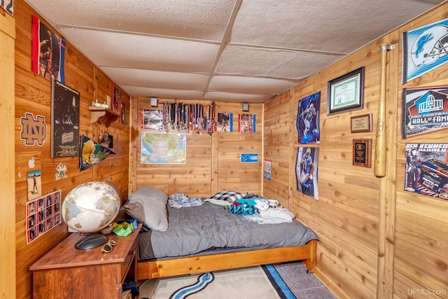 bedroom featuring carpet floors and wooden walls