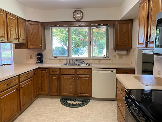 kitchen featuring decorative backsplash, dishwasher, and sink