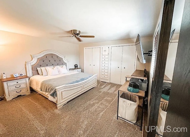 carpeted bedroom with ceiling fan and multiple closets