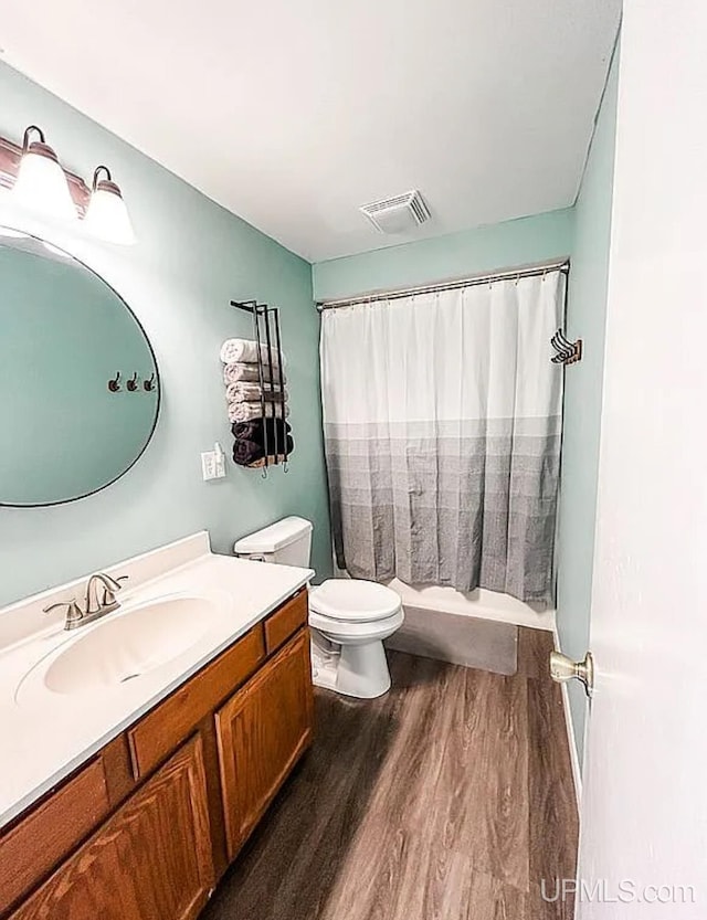 bathroom featuring wood-type flooring, vanity, and toilet