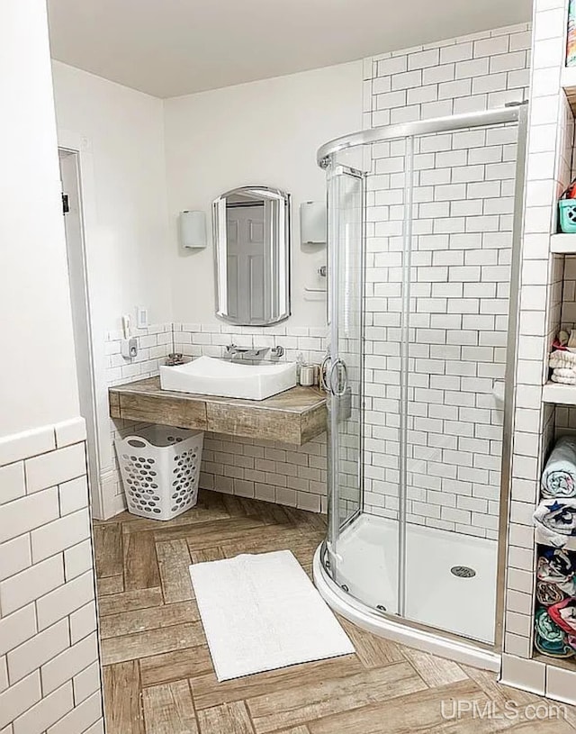 bathroom featuring tile walls, sink, parquet flooring, and a shower with shower door