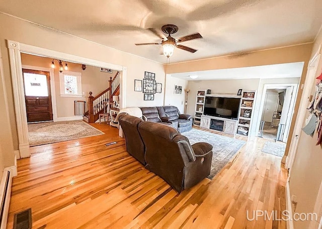 living room featuring hardwood / wood-style floors and ceiling fan