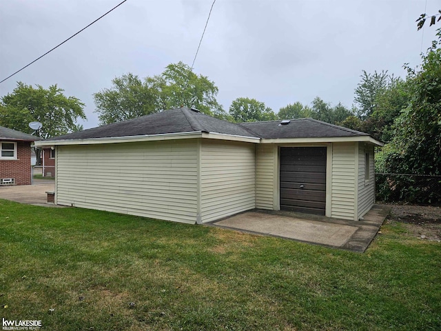 back of house featuring a garage and a lawn