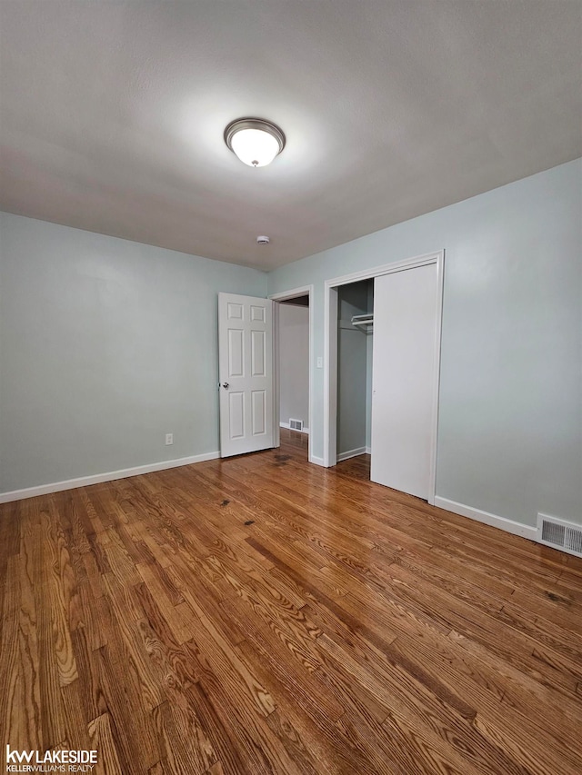 unfurnished bedroom featuring hardwood / wood-style floors and a closet