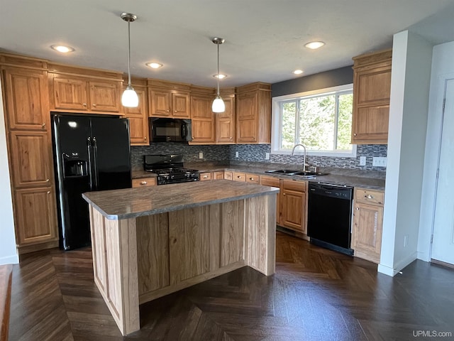kitchen featuring baseboards, a sink, black appliances, decorative backsplash, and a kitchen island