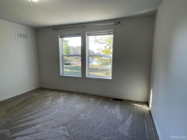 unfurnished room with baseboards, carpet, and visible vents
