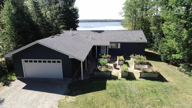 view of front of property with a water view, a front lawn, and a garage