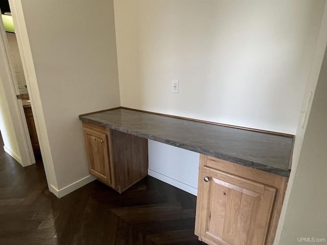 unfurnished office with built in study area and baseboards