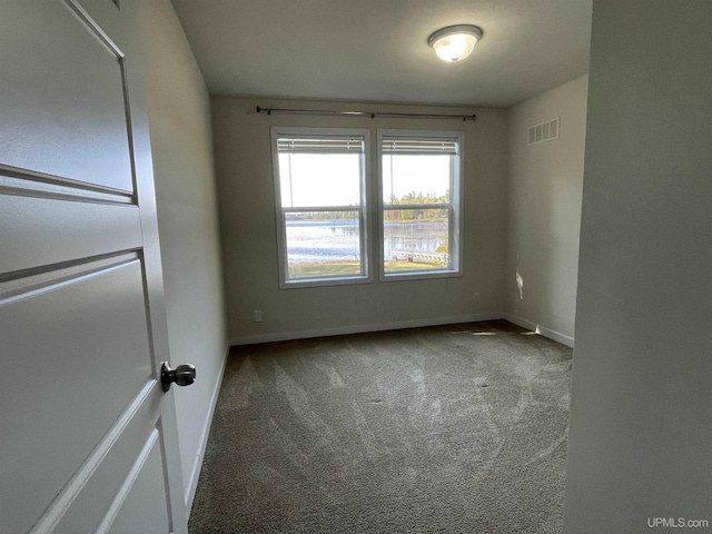 carpeted empty room with visible vents and baseboards