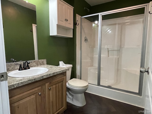 bathroom with toilet, vanity, and a stall shower