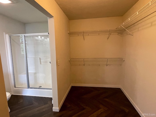 spacious closet with parquet flooring