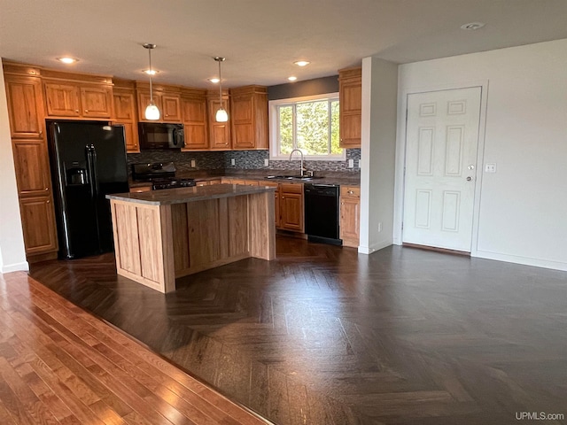 kitchen featuring sink, hanging light fixtures, a kitchen island, black appliances, and dark parquet floors