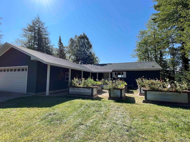 view of front of property with a front yard and a garage