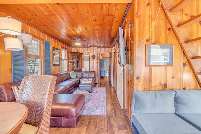 living room featuring wooden walls, ceiling fan, hardwood / wood-style flooring, and wooden ceiling