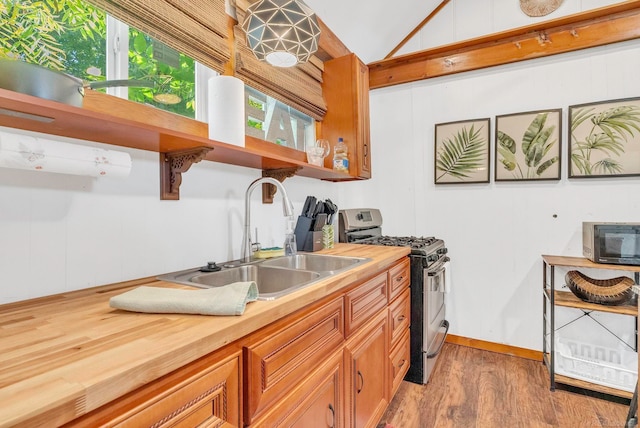 kitchen with gas stove, hardwood / wood-style floors, sink, and wood counters