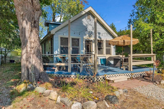 rear view of property with a sunroom and a deck