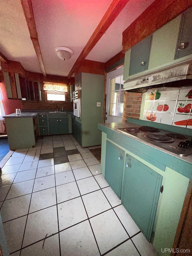 kitchen featuring light tile patterned floors, stainless steel cooktop, oven, and a wealth of natural light