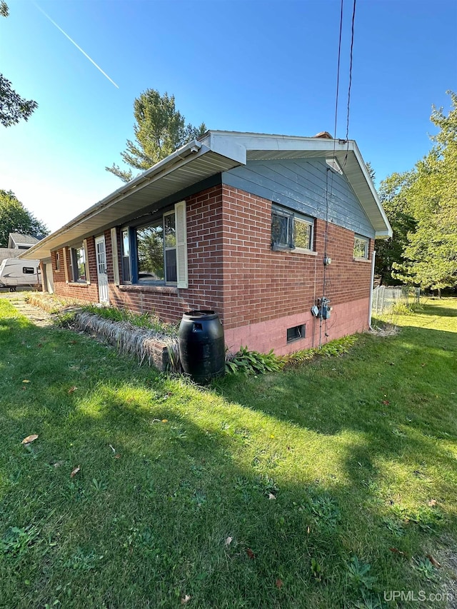 view of side of home with a lawn