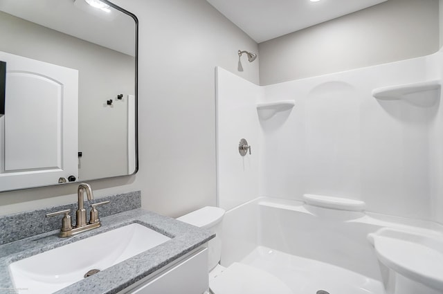 bathroom featuring walk in shower, vanity, and toilet