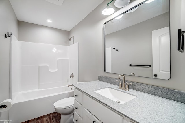 full bathroom with  shower combination, hardwood / wood-style flooring, vanity, and toilet