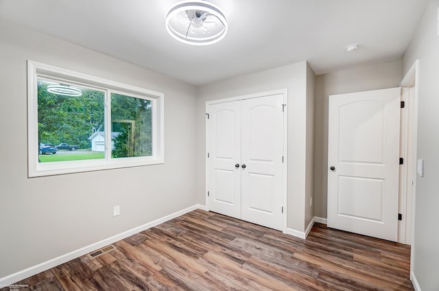 unfurnished bedroom featuring dark wood-type flooring and a closet