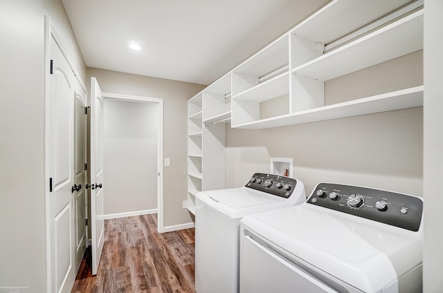 laundry area with wood-type flooring and washing machine and dryer