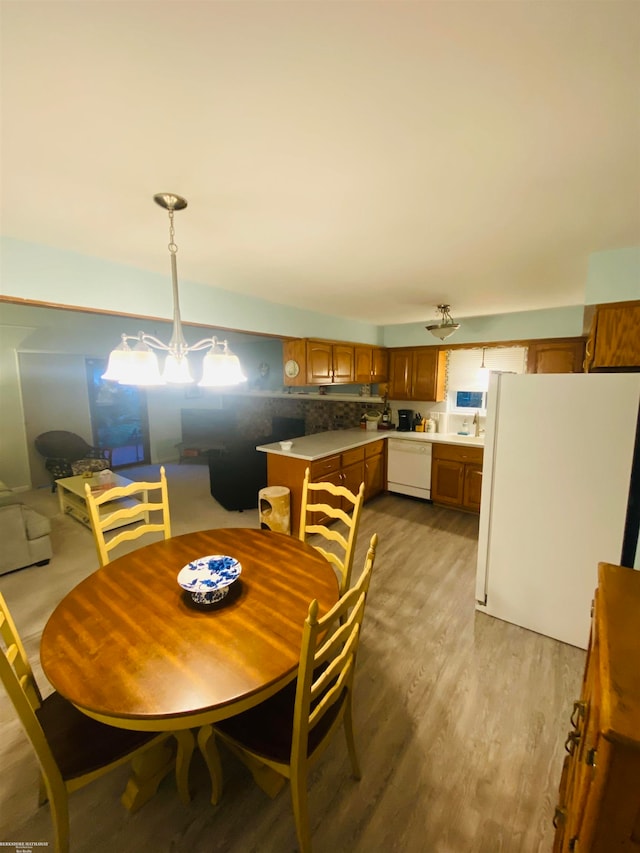 dining space with light hardwood / wood-style floors, a chandelier, and sink