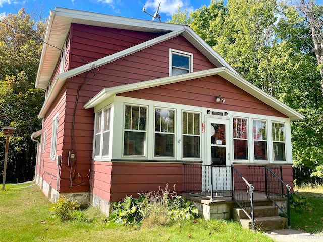 bungalow-style home with a front yard