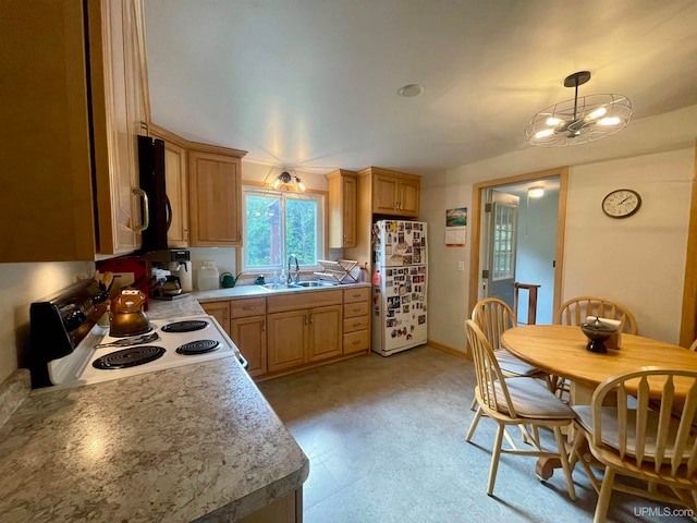 kitchen featuring white appliances, hanging light fixtures, and sink