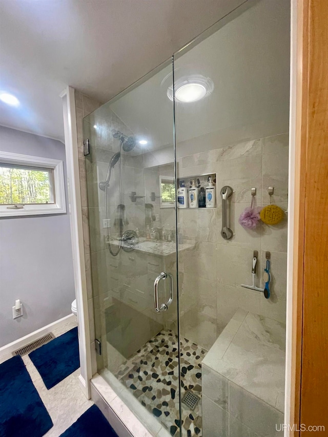 bathroom featuring an enclosed shower and toilet