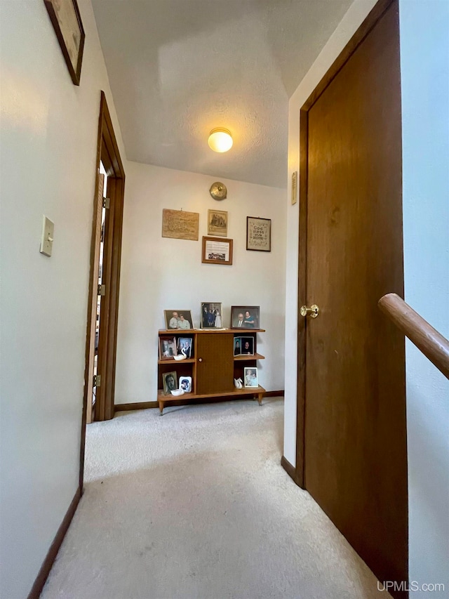 corridor featuring a textured ceiling and carpet