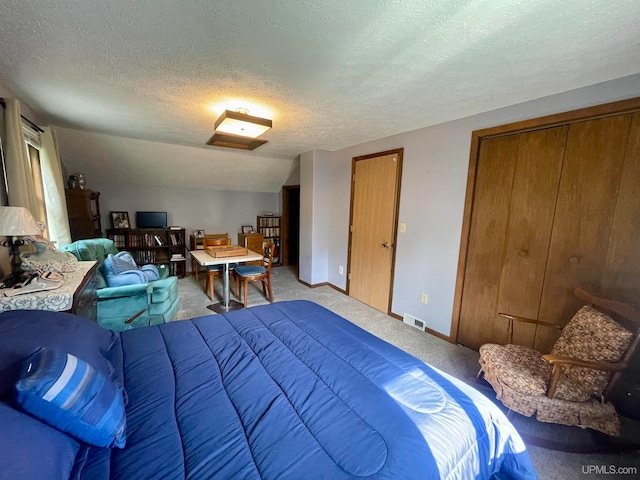 carpeted bedroom featuring lofted ceiling and a textured ceiling