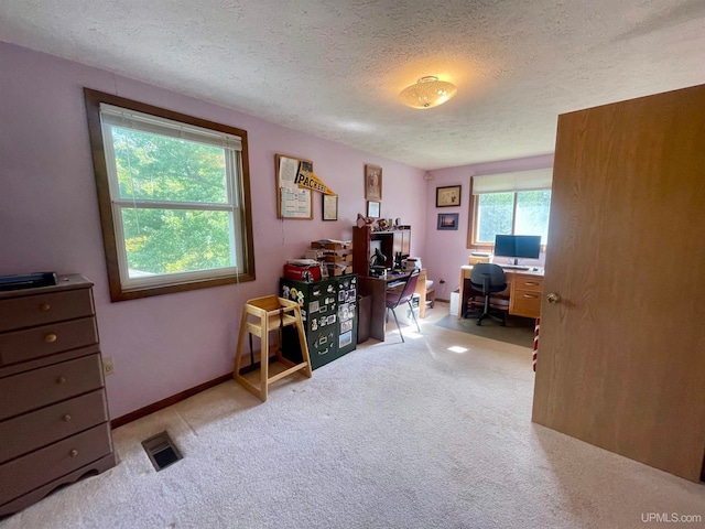 carpeted home office with a textured ceiling