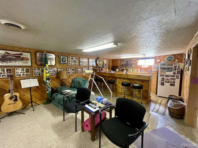 156 N Carlshend Rd, Skandia, MI 49885 - interior space with a bar, a textured ceiling, visible vents, and wooden walls