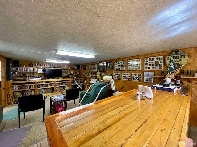 dining room featuring wood walls and a textured ceiling