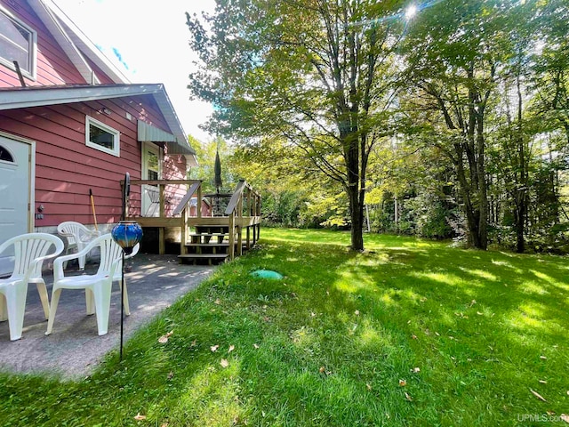 view of yard featuring a deck and a patio