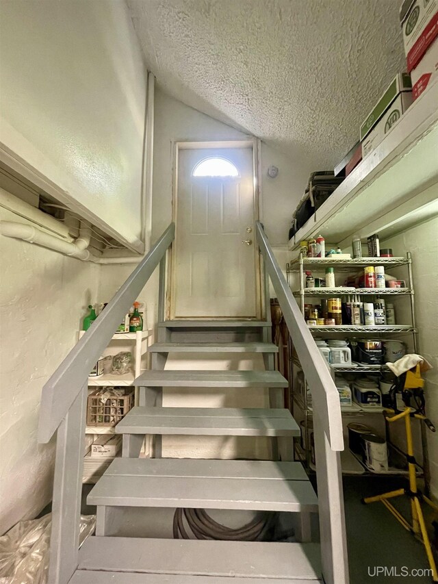 156 N Carlshend Rd, Skandia, MI 49885 - stairs with lofted ceiling and a textured ceiling