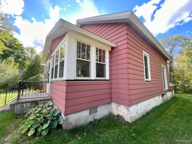 view of side of home with a yard