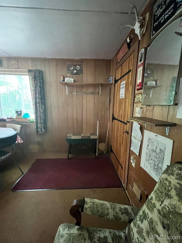 living room featuring wood walls and concrete floors