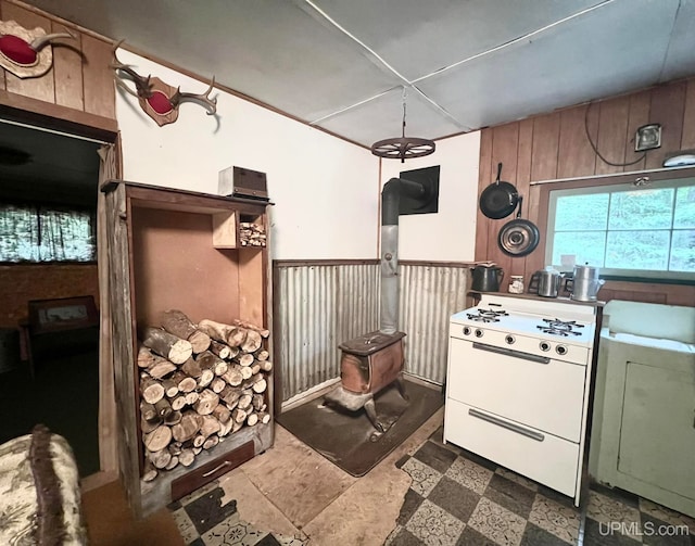 kitchen featuring white range oven and wood walls