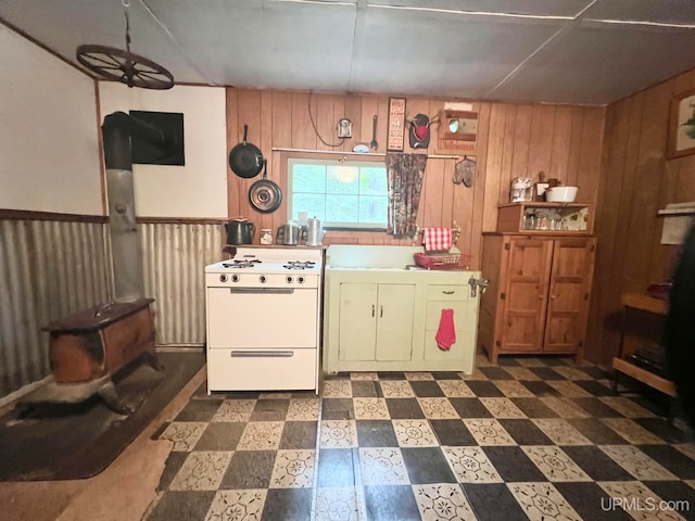 kitchen with white stove and wooden walls